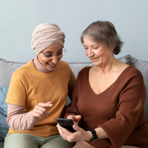 arabic-woman-is-teaching-senior-woman-use-smartphone-living-room